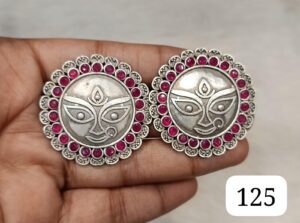 Pair of silver earrings with intricate design and pink stones around the edges.