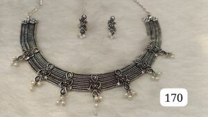 Silver necklace with intricate design and matching earrings featuring pearl accents.
