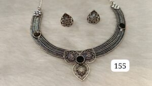 Silver jewelry set including a necklace with intricate designs and matching earrings with black accents.