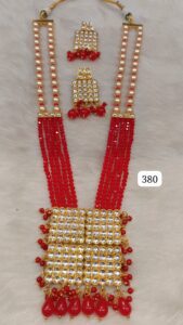 A red and gold beaded necklace set featuring multiple strands and decorative elements.