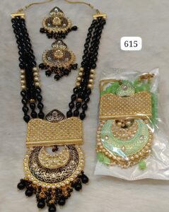 Traditional black and gold jewelry set featuring a necklace and matching earrings displayed with packaging.