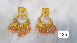 Pair of yellow and orange earrings with decorative elements and beads.