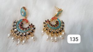 Gold and black earrings featuring intricate designs and pearl embellishments.