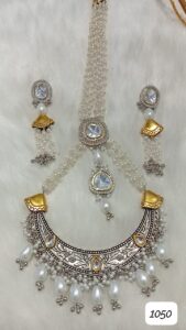 Traditional jewelry set featuring a necklace and matching earrings with silver and gold accents and pearls.