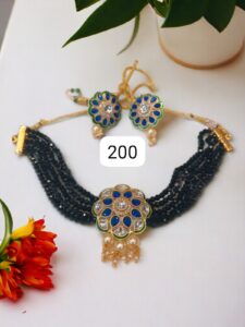 Traditional Indian necklace with blue stones and matching earrings displayed on a surface.