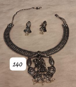 Traditional silver necklace with intricate design and matching earrings featuring pearl accents.