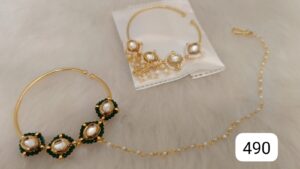 Gold jewelry set featuring a bracelet and matching earrings with green accents and pearls.