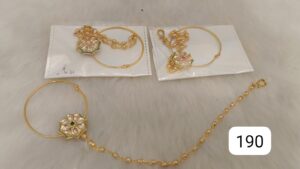 Gold jewelry set featuring earrings and a bracelet with floral designs and colored stones.