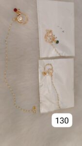 Two pieces of gold jewelry displayed in packaging with decorative elements and beads.