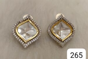 A pair of gold and silver decorative earrings featuring a diamond-shaped clear stone surrounded by small stones.