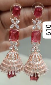 Pair of red and silver earrings featuring intricate designs and gemstones.