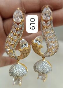 Gold and silver decorative earrings with intricate designs and sparkling stones.