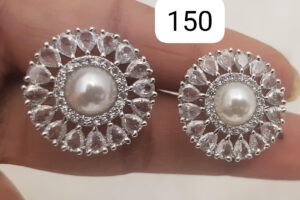 Pair of silver earrings featuring a central pearl surrounded by a decorative arrangement of clear stones.