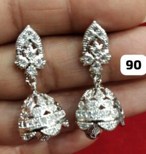 Pair of silver decorative earrings with intricate designs and a hanging element.