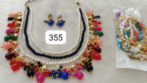 Three-layered colorful beaded necklace with matching earrings and additional jewelry pieces in a plastic bag.