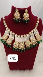 Traditional Indian jewelry set featuring a necklace and matching earrings with green beads and gold accents.