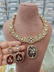 Traditional Indian jewelry set featuring a necklace and matching earrings displayed on a bust.