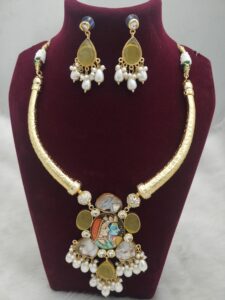 Gold-tone traditional Indian necklace with a central pendant and matching earrings.