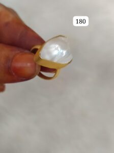 Gold ring featuring a large, irregularly shaped pearl set in a simple band.