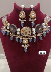 Traditional Indian necklace with intricate design and matching earrings displayed on a bust.