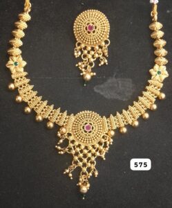 Gold necklace with intricate design and matching earrings featuring colored gemstones.