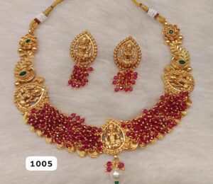 Gold necklace with ruby accents and matching earrings featuring intricate designs.