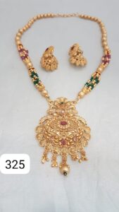 Gold necklace with intricate design and matching earrings featuring colorful embellishments.